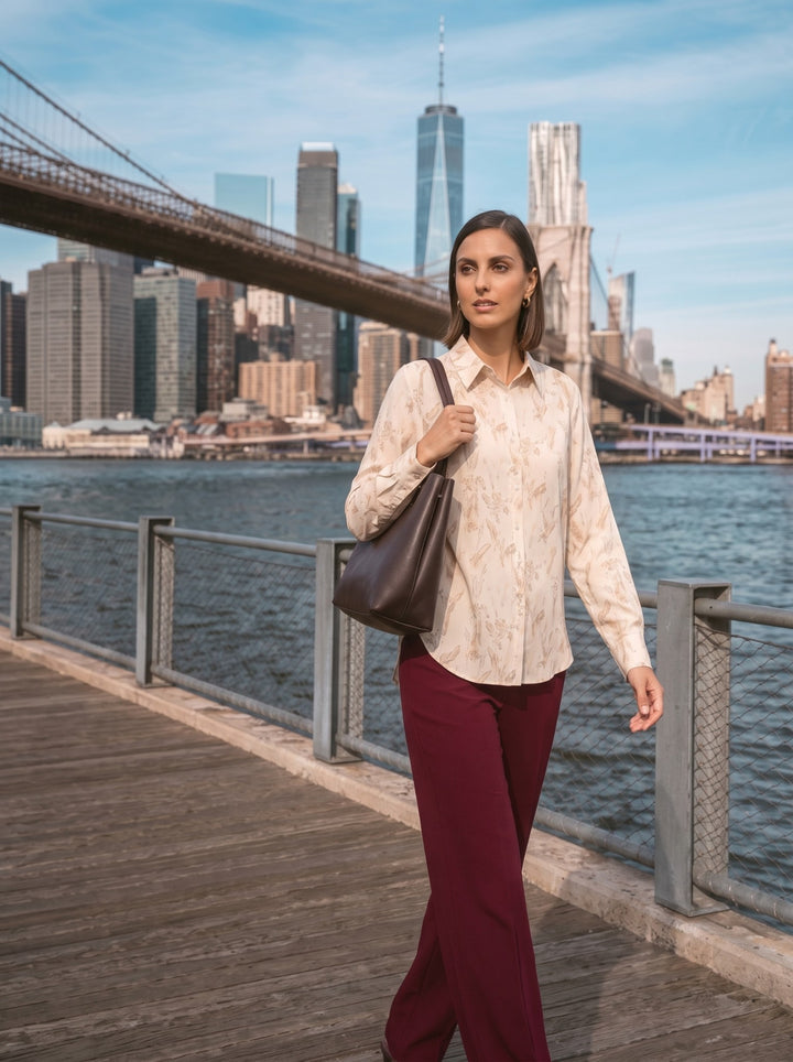 Model wearing the abstract print button-down shirt untucked with burgundy wide-leg trousers side 1