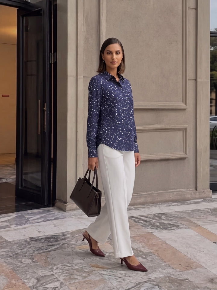 Full-length shot of model walking in untucked navy botanical print long-sleeve shirt